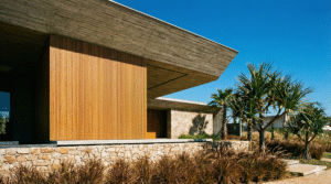 Fachada de casa em Rio Preto com madeira, concreto e pedra resistentes ao sol.